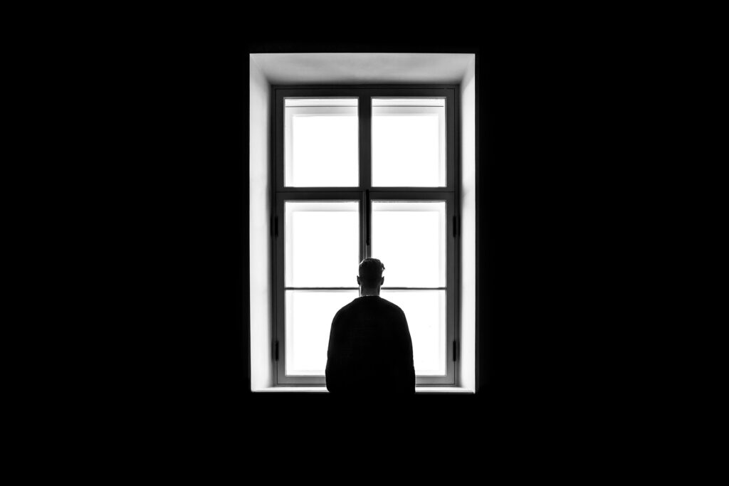 man standing near window | affected by anxiety and depression